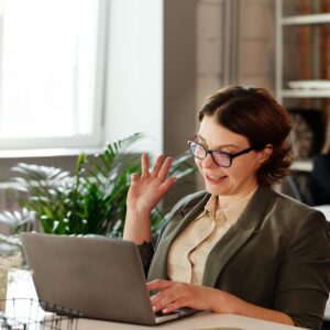 Businesswoman in glasses on a video call in a stylish office setting.
